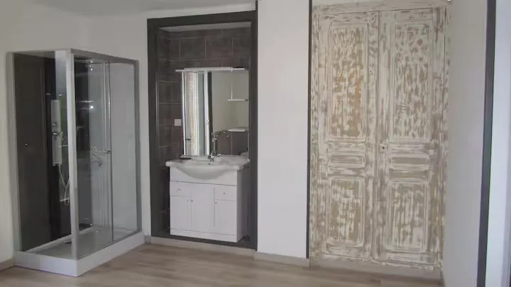 Une salle de bain avec cabine de douche et meuble vasque